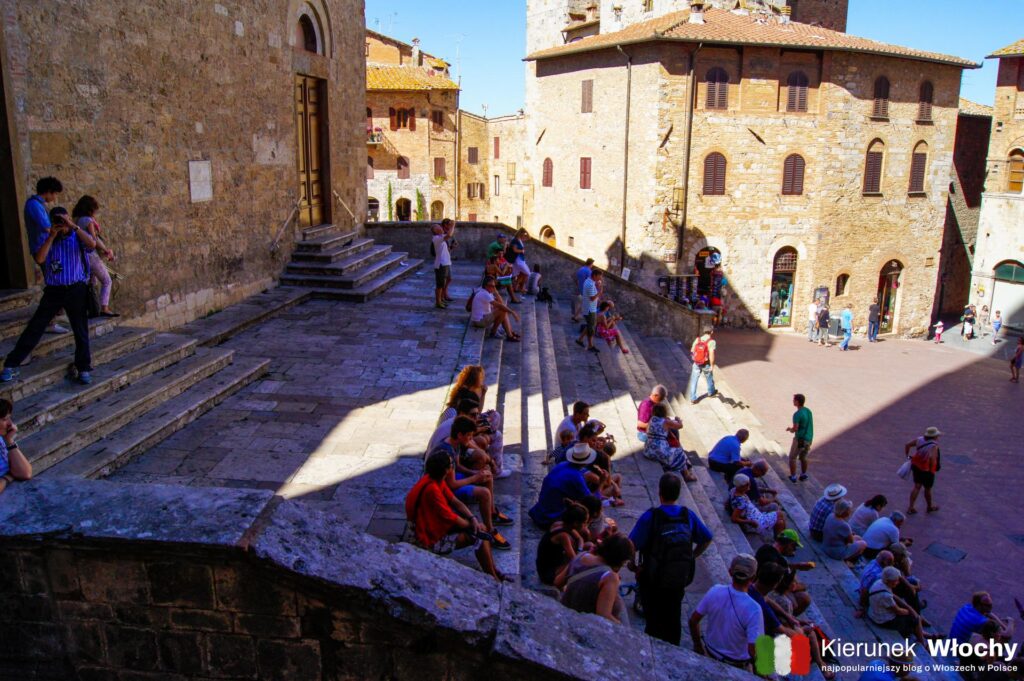 turyści wypoczywający na schodach przed katedrą w San Gimignano, Toskania, Włochy (fot. Łukasz Ropczyński, kierunekwlochy.pl)