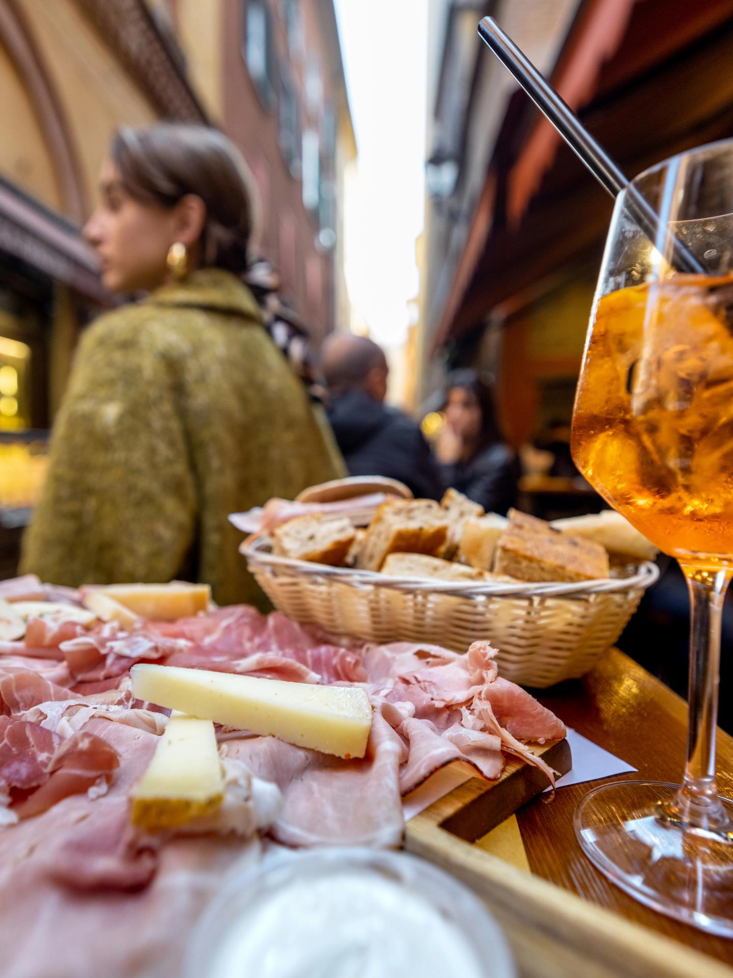 deska lokalnych serów i wędlin, chrupiące przekąski i spritz czyli aperitivo na Via Pescherie Vecchie, Bolonia, Emilia-Romania, Włochy